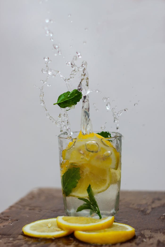 trusted-partner Dynamic shot of lemon and mint slices splashing in water, a refreshing still life.